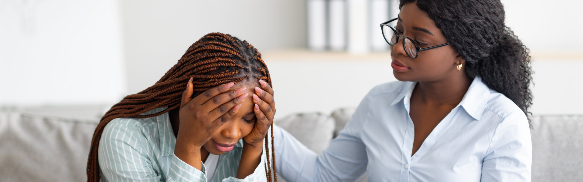 professional psychotherapist comforting depressed female patient at office