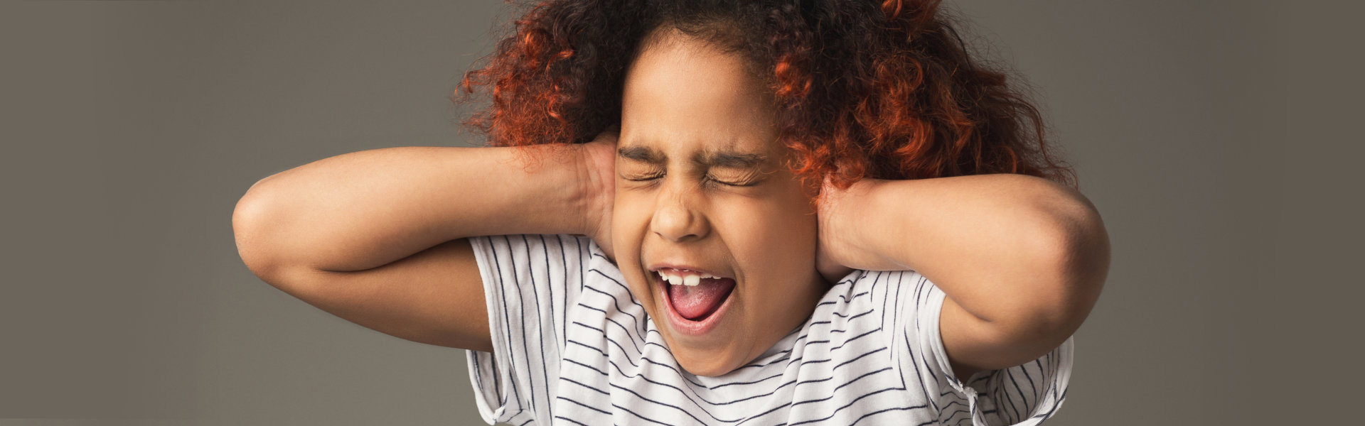 young girl covering her ears